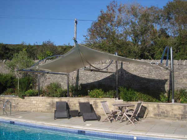 Front view of cantilevered tensile sail over poolside terrace. Bespoke, one off unique structure by Alfresco365