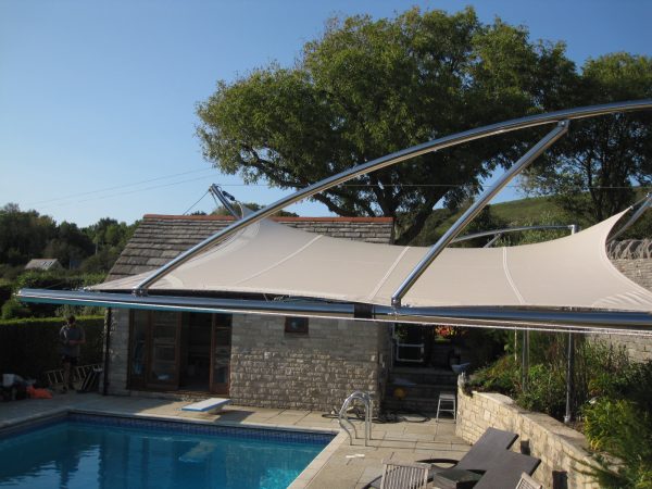 Close up of cantilevered tensile sail over poolside terrace. Bespoke, one off unique structure by Alfresco365